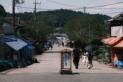 People on street amidst buildings in city