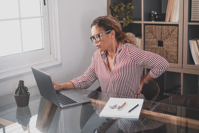 Woman using smart phone while sitting on table