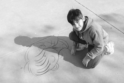 Portrait of boy drawing on the floor