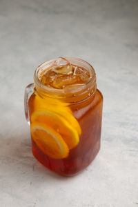 Close-up of orange juice in glass jar on table