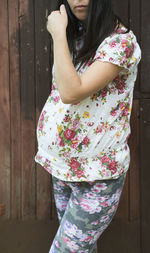 Midsection of pregnant woman standing against wooden door