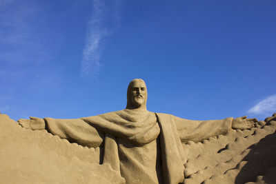 Low angle view of statue against blue sky