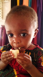 Close-up portrait of girl eating food at home