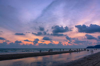 Scenic view of beach against sky at sunset