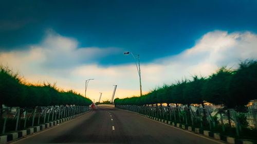 Road amidst trees against sky