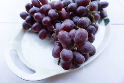 High angle view of grapes in plate on table