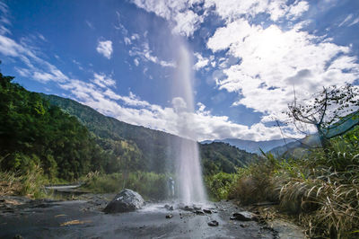 Scenic view of waterfall against sky