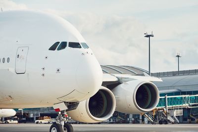 Airplane on airport runway against sky