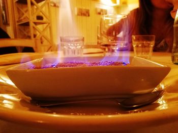 Close-up of illuminated tea light candle on table