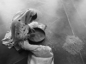 Woman cleaning wheat while sitting at home