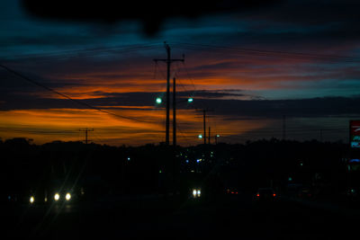 Silhouette street against sky during sunset