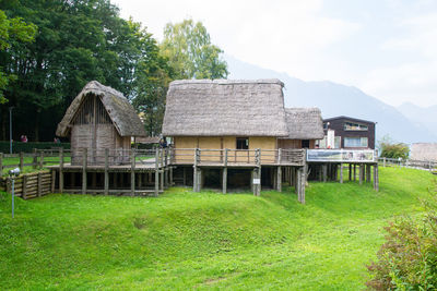 Barn on field by building against sky