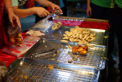 Person preparing food on barbecue grill at market