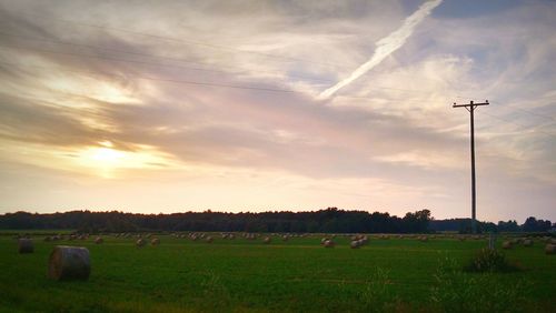 Scenic view of grassy field against cloudy sky