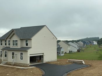 Houses by buildings against sky