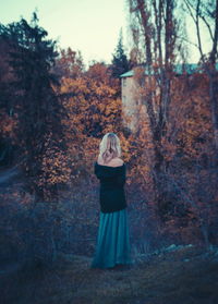 Rear view of mid adult woman in park during autumn