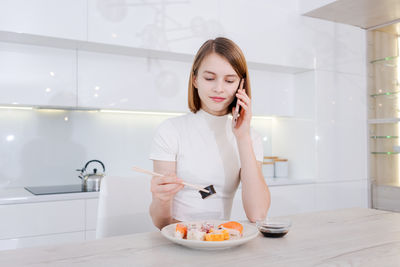 Portrait of young woman sitting at home