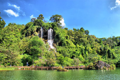 Scenic view of waterfall in forest against sky