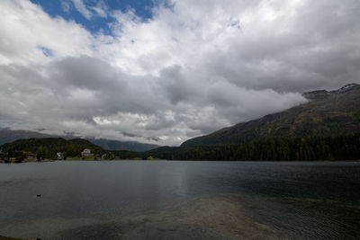 Scenic view of lake by mountains against sky