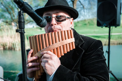 Portrait of man wearing sunglasses holding hat