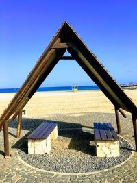 Built structure on beach against clear blue sky