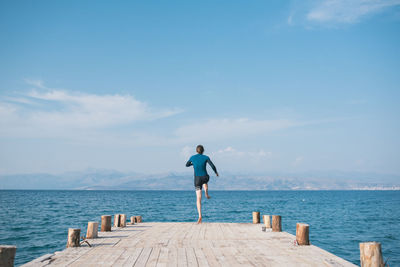 Rear view of man against sea against sky