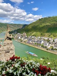 Scenic view of lake amidst green mountains against sky