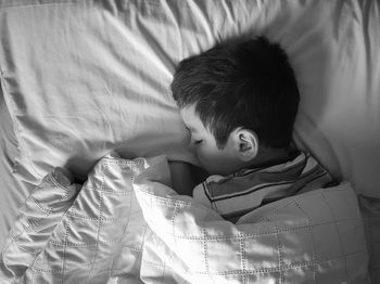 High angle view of boy sleeping on bed at home