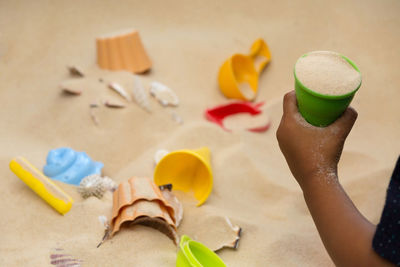 High angle view of baby hands playing with sand