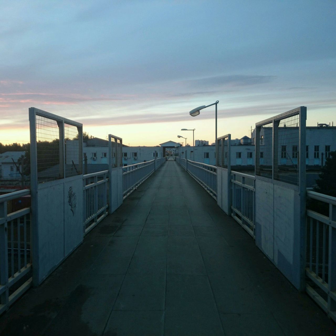 architecture, built structure, building exterior, the way forward, sky, diminishing perspective, sunset, cloud - sky, vanishing point, transportation, cloud, city, outdoors, cloudy, residential structure, road, street, house, empty, no people