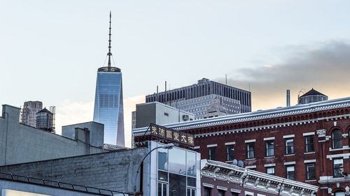 Low angle view of one world trade center by buildings against sky