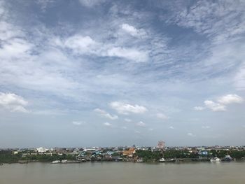 Sea by buildings against sky in city