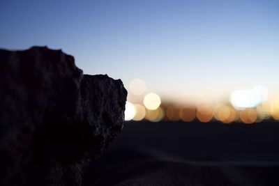 Scenic view of rocks against clear sky at sunset
