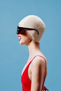 Portrait of woman wearing hat against blue background