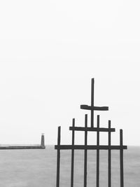 Wooden structure in sea against clear sky