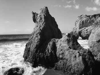 Scenic view of rock formation by sea against sky