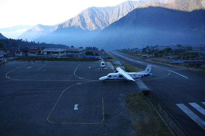 Airplane flying over mountain against sky