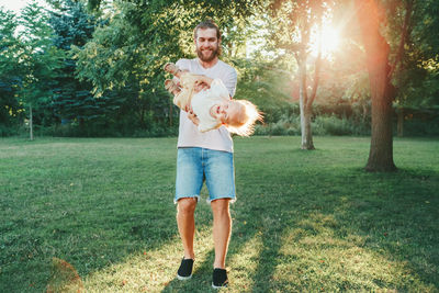 Portrait of man holding horse standing by tree