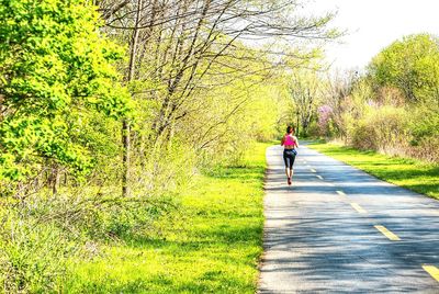 Rear view of woman walking on footpath