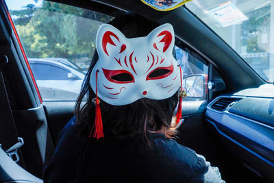 Woman wearing mask while sitting in car