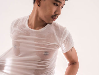 Portrait of young man standing against white background