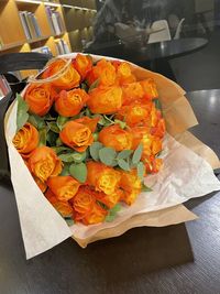 High angle view of orange roses on table