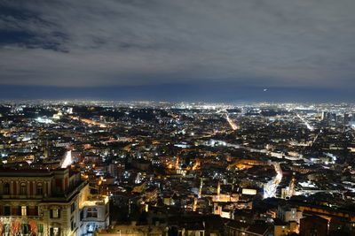 High angle view of illuminated cityscape against sky at night