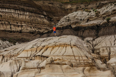 Boy running on the hoodoos in drumheller, alberta