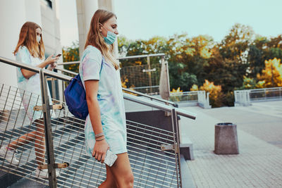 Full length of woman standing against railing