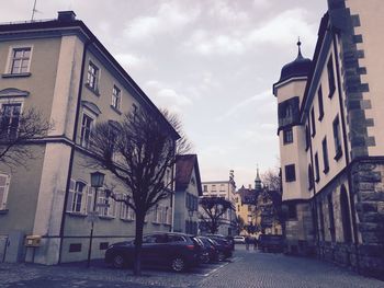 Buildings in city against cloudy sky