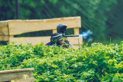 Soldier using weapon while hiding behind plants