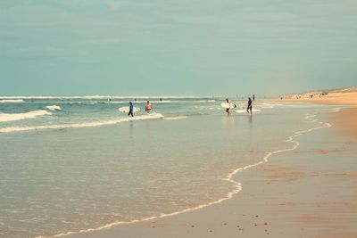 People on beach against sky