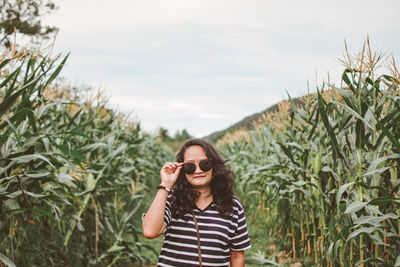 Portrait of mid adult woman wearing sunglasses while standing at farm