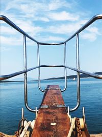 Close-up of metal railing against sky sea